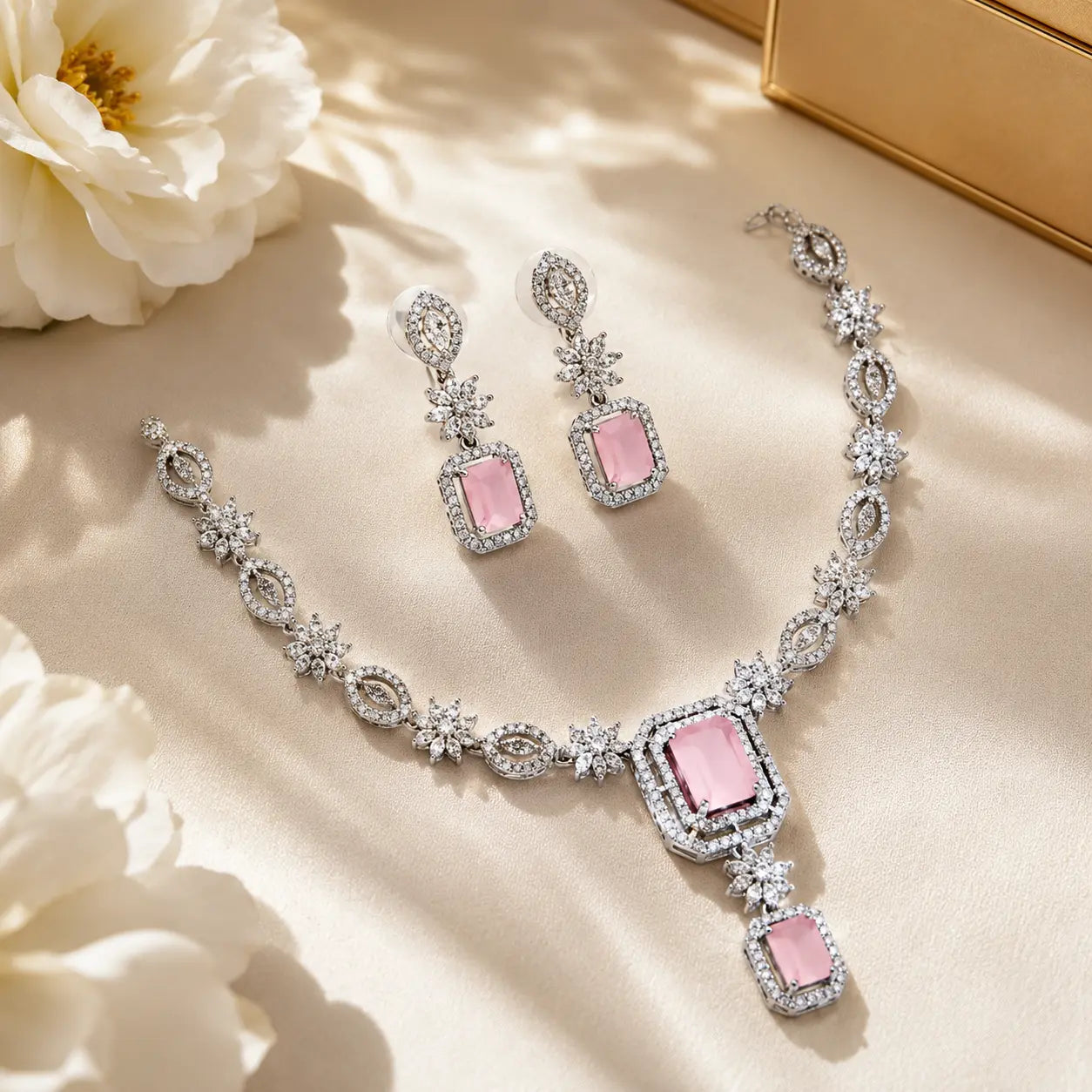 Jewelry set with pink stones on a beige surface with flowers